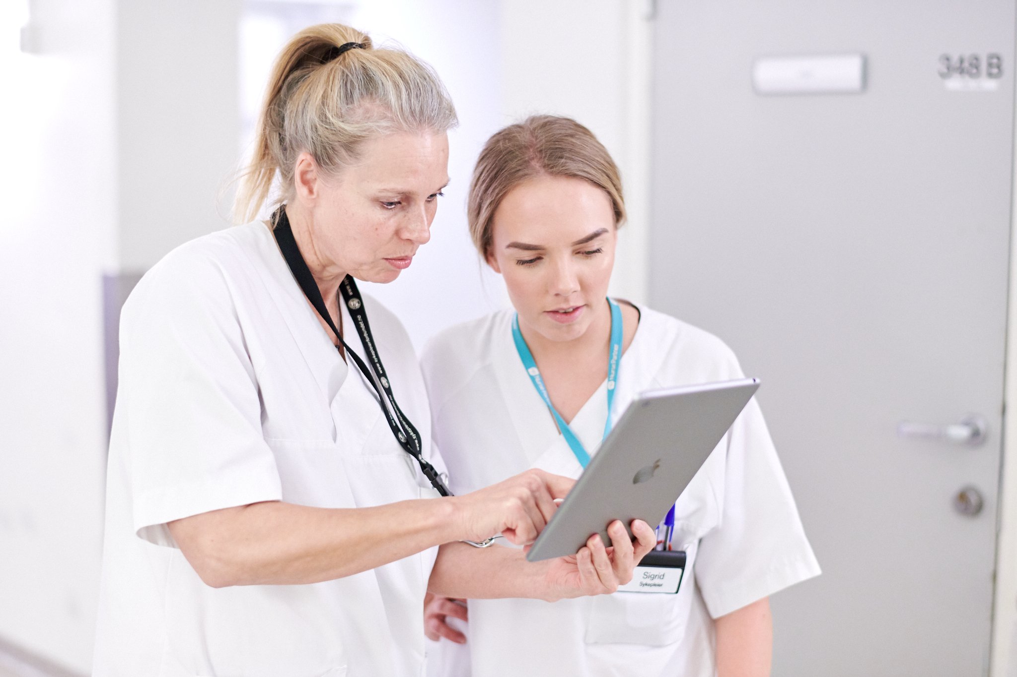 To sykepleiere ser på nettbrett